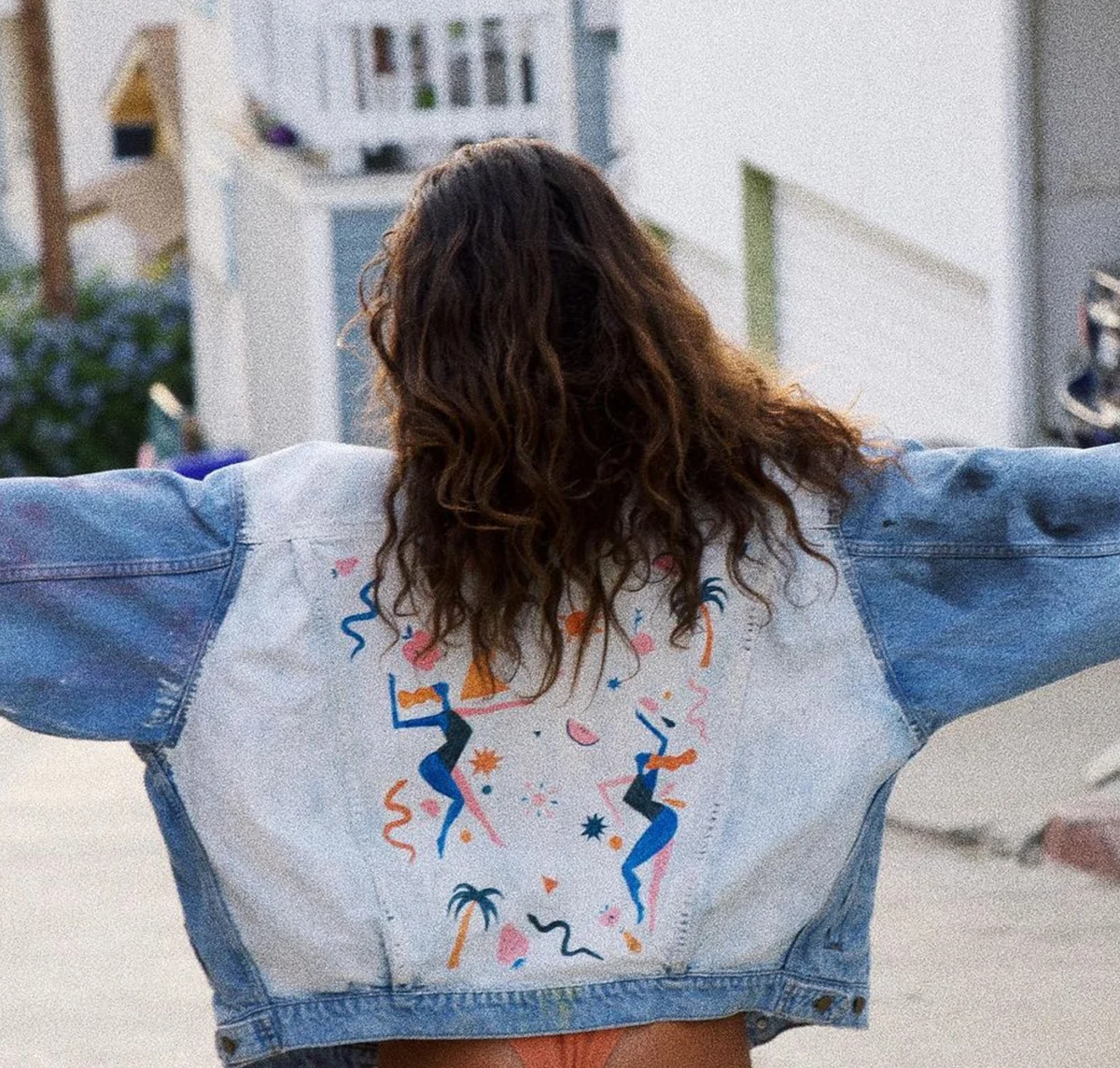Back of a light-wash Levi’s jacket hand-painted with dancing figures, palm trees and fruit