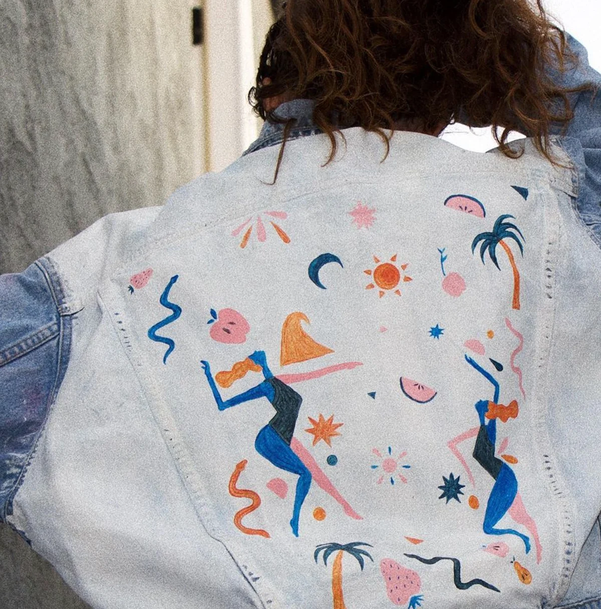 Close-up of a hand-painted Levi’s jacket with dancing figures and fruit