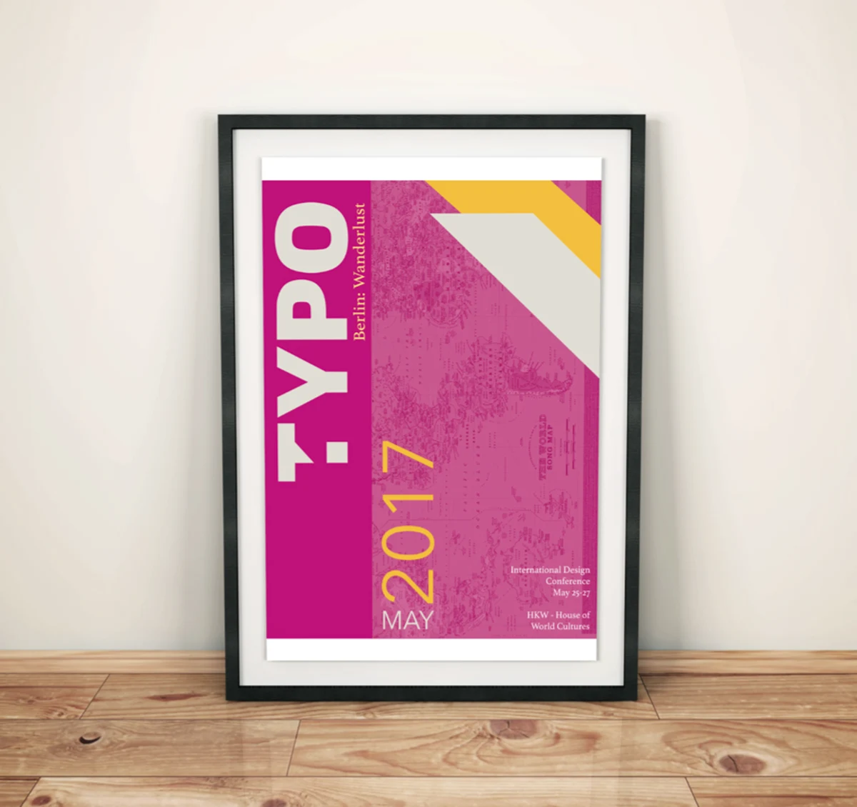 Framed magenta poster for TYPO Berlin: Wanderlust, May 2017, with large vertical type over a world map